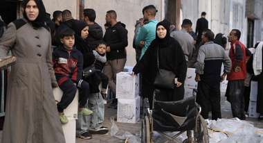 Menschen stehen Schlange bei der Verteilung von Paketen mit Hilfsgütern in Gaza-Stadt.
