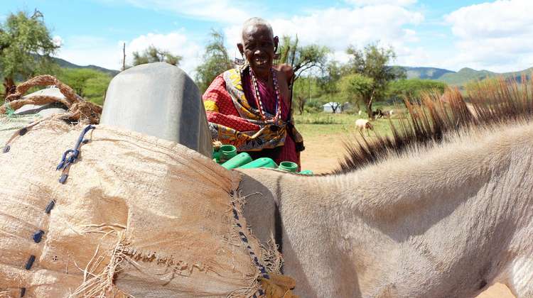 Eine Massai-Frau in Kenia holt mit ihrem Esel Wasser an einem Bohrloch der Welthungerhilfe.