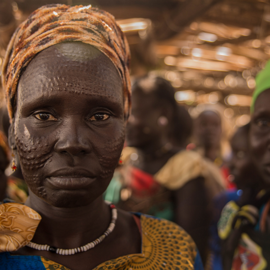 Eine südsudanesische Frau schaut im Porträt direkt in die Kamera.