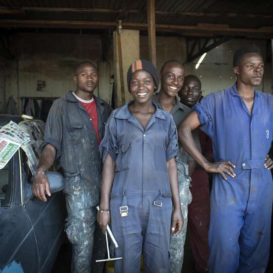 Eine Gruppe Jugendlicher in einer Autowerkstatt