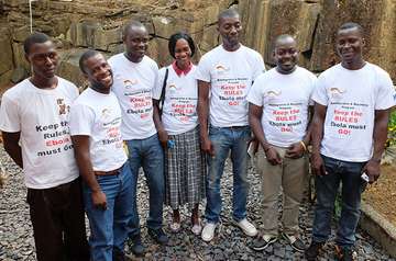 Mehrere Bürger tragen ein T-Shirt mit der Aufschrift "Keep the rules, ebola must go" 