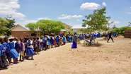 Kinder stehen Schlange für eine Schulspeisung an ihrer Grundschule in Malawi.
