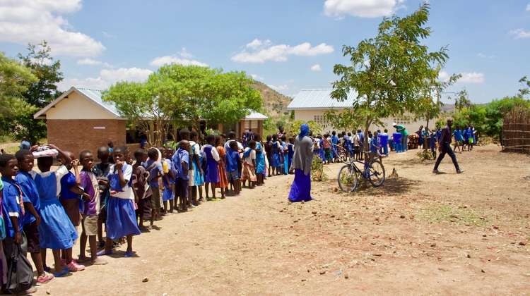 Kinder stehen Schlange für eine Schulspeisung an ihrer Grundschule in Malawi.