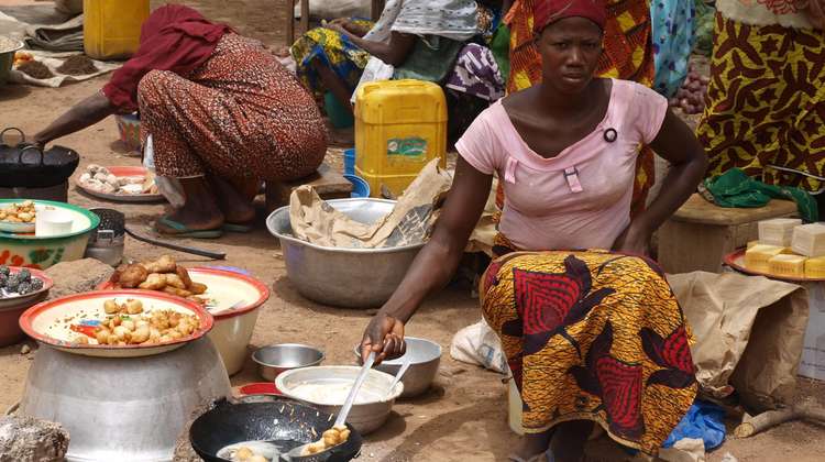 Kleinbäuerinnen bereiten Speisen zu und verkaufen sie auf dem Markt in Burkina Faso.