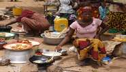 Kleinbäuerinnen bereiten Speisen zu und verkaufen sie auf dem Markt in Burkina Faso.