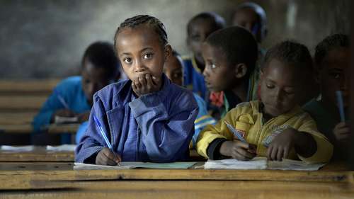 Wer hungert, kann nicht lernen. Bild: Ein Mädchen sitzt an einer Schulbank.