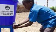 Ein Kind wäscht sich die Hände an einer malawischen Grundschule.
