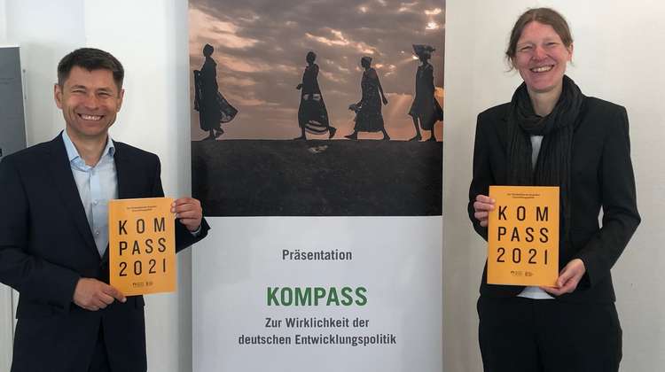 Vorstellung des Kompass 2021. Mathias Mogge und Birte Kötter halten jeweils ein orangefarbenes Heft mit Kompass 2021-Logo in den Händen. 
