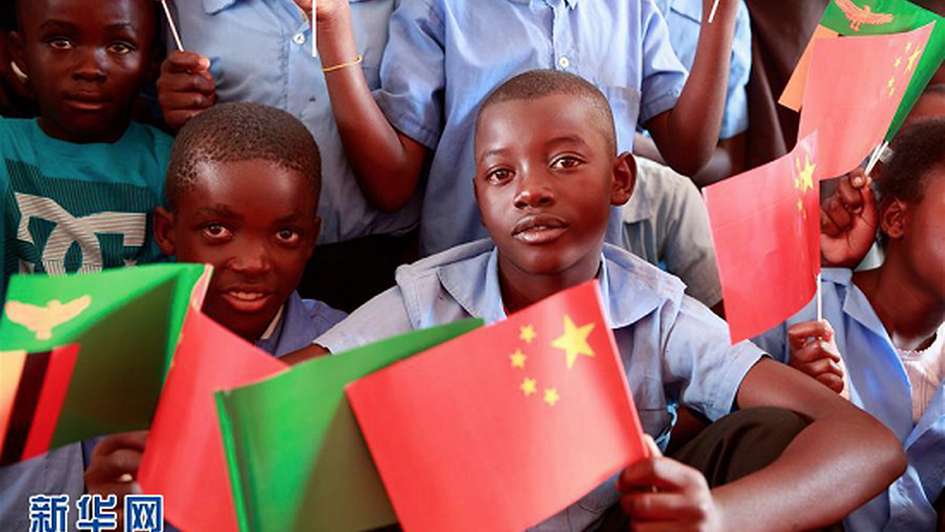 Schulkinder in Sambia mit chinesischer Flagge in der Hand. 