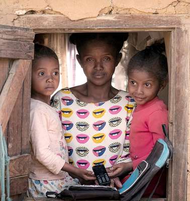 Eine alleinerziehende Mutter und ihre beiden Kinder schauen aus dem Fenster. Bargeldtransfers im Rahmen vorausschauender humanitärer Hilfe ermöglichen der Familie, auch in Krisenzeiten für sich sorgen zu können.