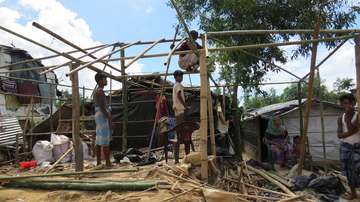Eine Rohingya-Familie baut ein Zelt auf.