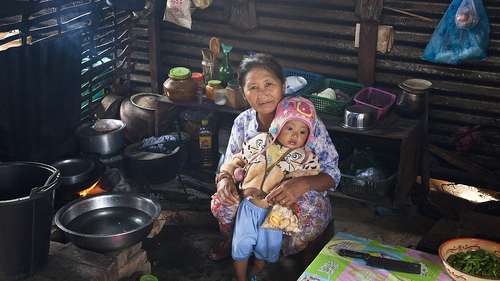 Eine Geflüchtete aus Myanmar mit ihrem Enkel in einer improvisierten Hütte im Flüchtlingscamp, Myanmar.