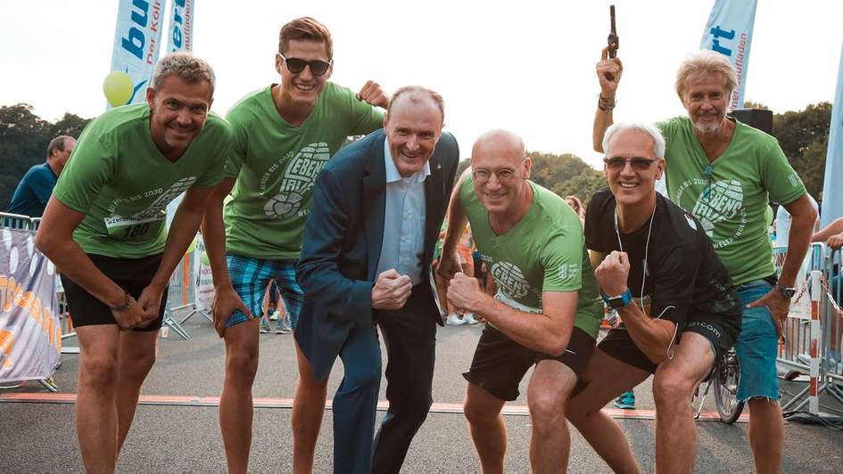 Die sechs Männer posieren vor der Startmarke des ZeroHungerRuns in Köln.
