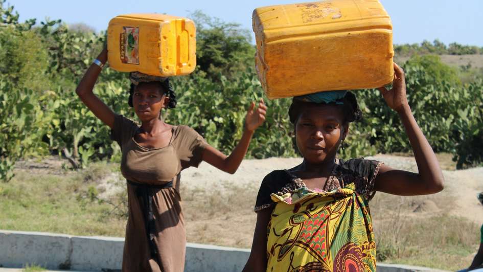 Zwei Frauen tragen Wasserkanister auf ihren Köpfen, Madagaskar 2021.