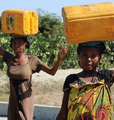 Zwei Frauen tragen Wasserkanister auf ihren Köpfen, Madagaskar 2021.