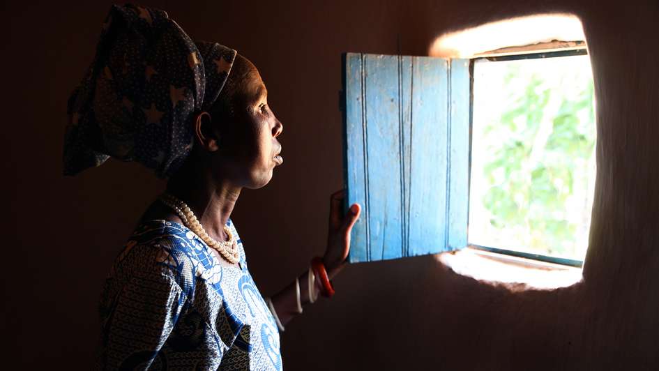 Baeuerin in Ruanda schaut aus dem Fenster.