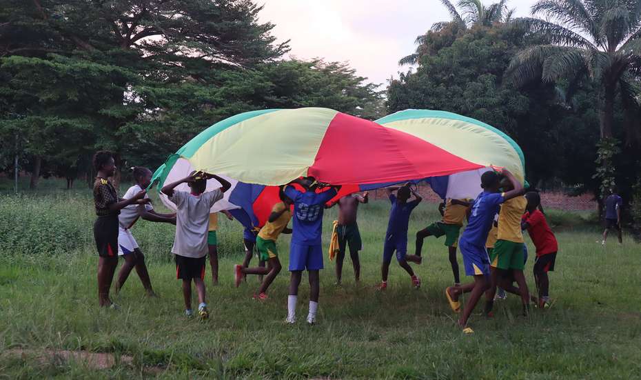 Kinder spielen mit einem großen Tuch im Freien, Zentralafrikanische Republik, 2021.