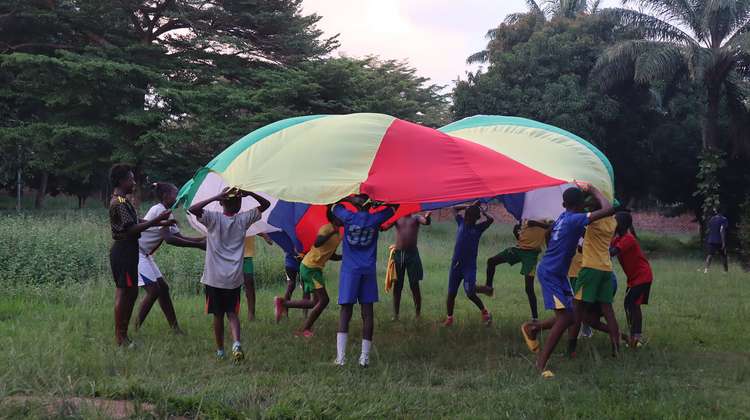 Kinder spielen mit einem großen Tuch im Freien, Zentralafrikanische Republik, 2021.