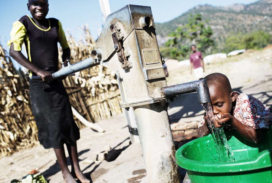 WASH-Projekt in Malawi: Ein Junge trinkt aus einem Brunnen.