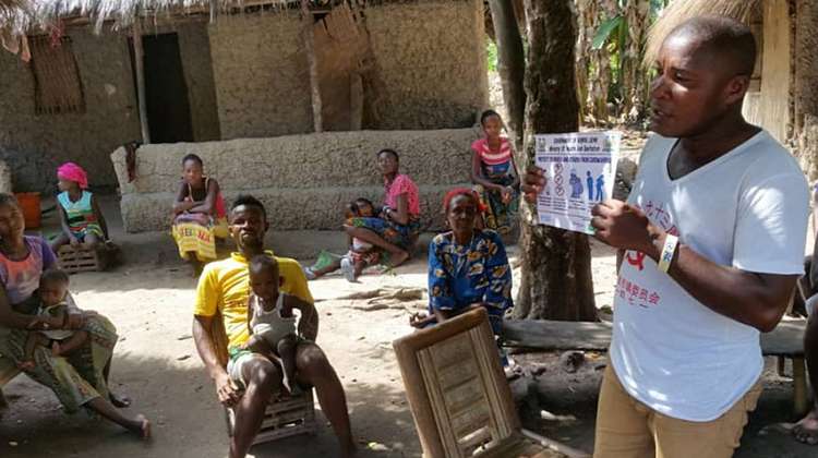 Gemeindemitglieder im Bezirk Bonthe, Sierra Leone, erhalten Informationen über Verhaltensweisen, die dazu beitragen, die Übertragung des Virus zu verlangsamen.