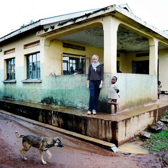 Schauspielerin Gesine Cukrowski mit einem kleinen Kind vor einem Krankenhaus in Uganda 