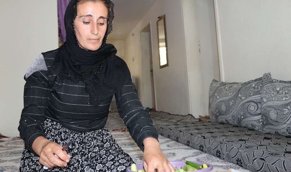 Eine Frau kniet auf dem Boden und schneidet Gurken, Türkei 2021.