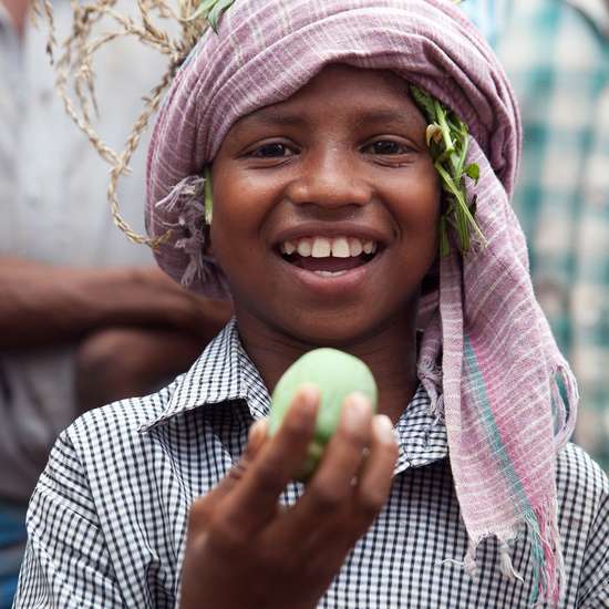 Der achtjährige Jalia Pacharia hält sein Lieblingsessen in die Höhe: einer wilde Gurke. Die Paharia im indischen Dorf Ketokuria sammeln seit jeher Dutzende Sorten wilder Waldgewaechse wie Knollen, Wurzeln, Früchte und Gemüse, doch durch Waldrodungen, finden sie immer weniger Essbares. Der Welthungerhilfe-Partner CWS/Avibyakti Foundation hilft ihnen, die Vielfalt zu erhalten. 