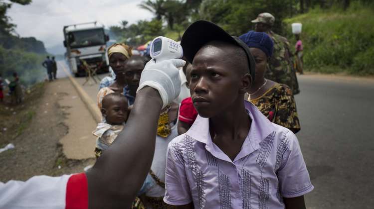 Measuring of body temperature of people crossing the Ebola-checkpoint “Mile 4”.