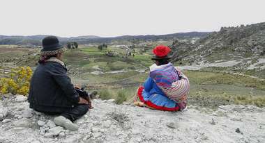 Berglandschaft in Lima, im Vordergrund zwei Frauen, die mit dem Rücken zur Kamera sitzen