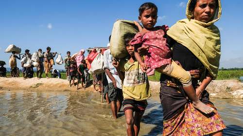 Hilfe für Rohingya in Bangladesch. Bild: Eine Reihe an Menschen überquert einen Fluss.