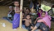 Eine Familie in einer überdachten Unterkunft im Flüchtlingslager in Bangladesch.
