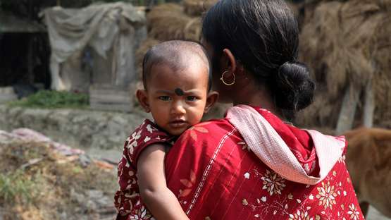 Eine Mutter hält ihr Kind auf dem Arm, Indien 2021.