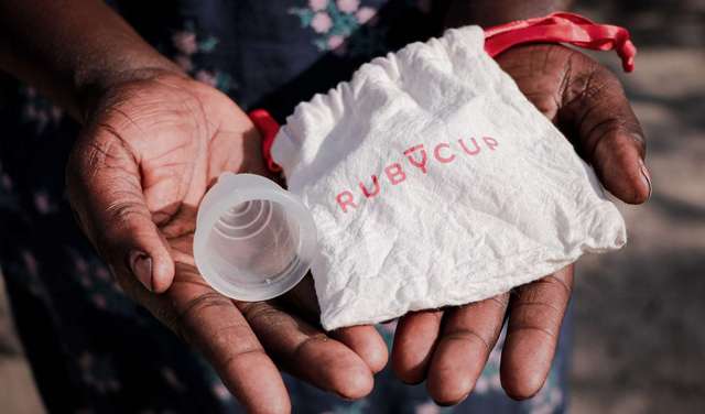 Eine Frau hält eine Menstruationstasse in der Hand, Südsudan 2022. 
