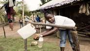 Eine Frau wäscht ihre Hände am Tipi Tap. Mit dieser einfachen Vorrichtung wird die Hygiene im von Ebola betroffenen Sierra Leone verbessert.