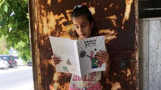 Ein Mädchen liest in einem Heft.