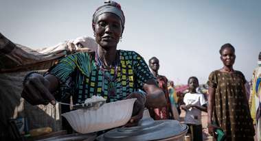 Eine Frau füllt eine Schüssel mit Reis.