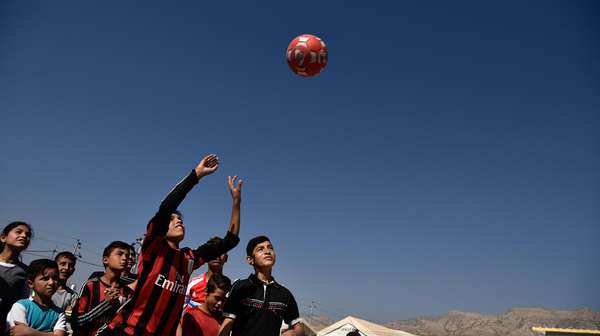 Jesidische Kinder werfen Ball in die Luft