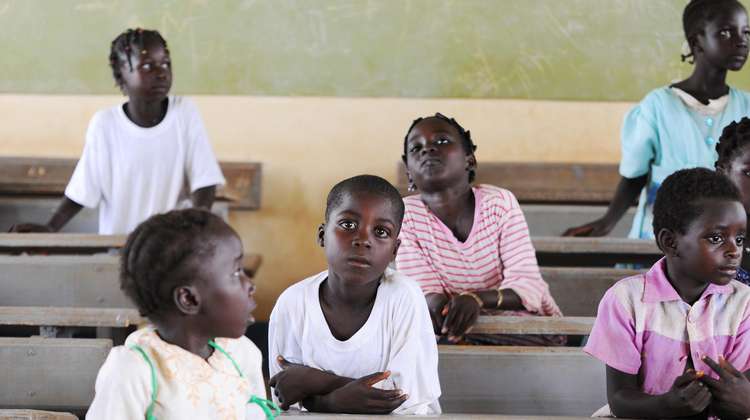 Hilfe für Kinder in Burkina Faso. Bildbeschreibung: Kinder sitzen hintereinander in Schulbänken