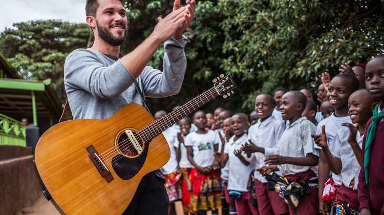 Sänger und Songwriter Robert Redweik mit Gitarre bei seinem Besuch des "Skill up!"-Projekts der Welthungerhilfe in Kenia.
