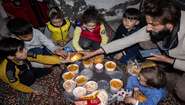 Eine Familie isst eine Mahlzeit der Suppenküche für Erdbebenopfer, Mardin/Türkei 2023.