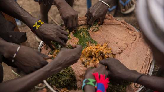 Verschiedene Menschen essen Kisra in Bentiu, Südsudan.