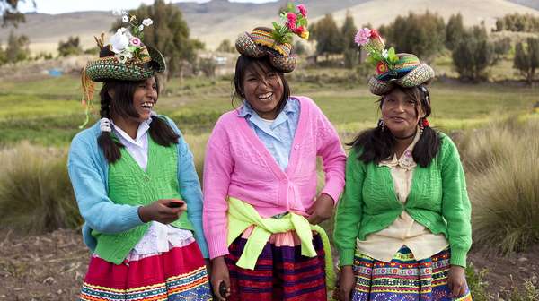 Drei junge Frauen in peruanischer Tracht bei der Gemeinschaftsarbeit