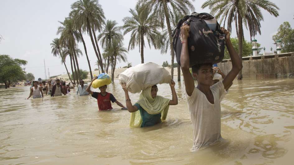 Überschwemmung in Pakistan: Familien kämpfen sich durch die Wassermassen.