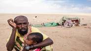 Ein erschöpfter Vater mit seinem Kind in Somaliland