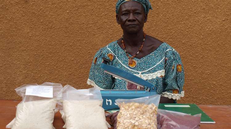 Eine Frau verkauft selbst angebaute Produkte an ihrem Marktstand
