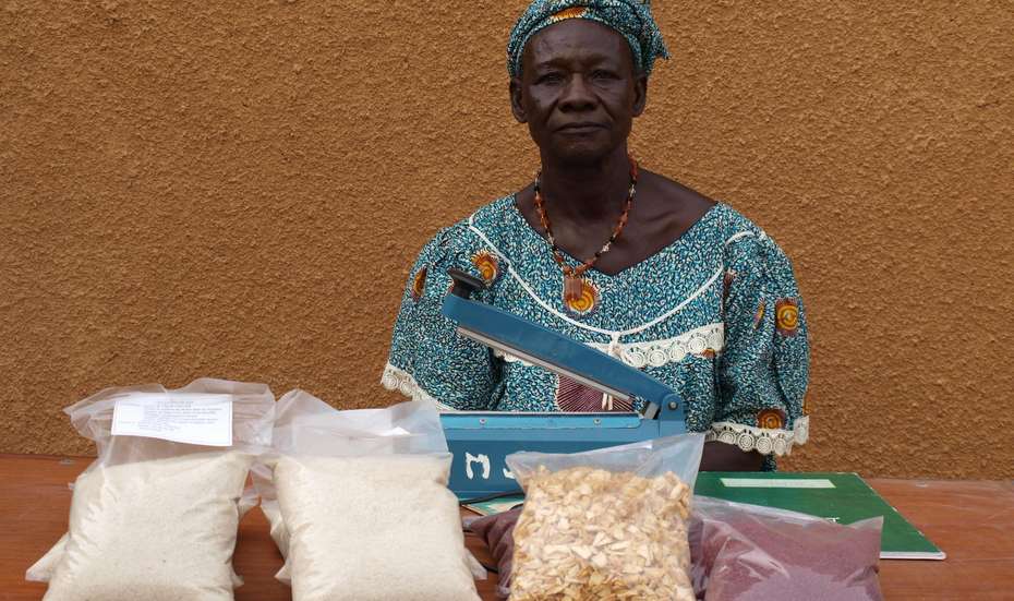 Eine Frau verkauft selbst angebaute Produkte an ihrem Marktstand