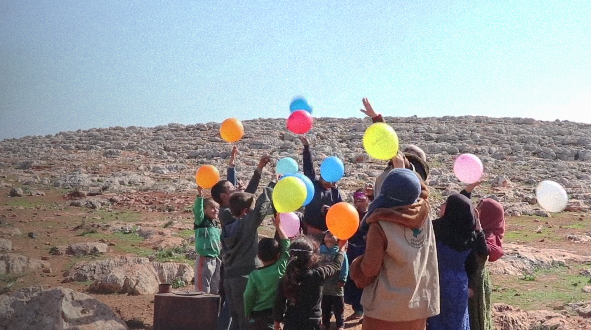 Kinder in Syrien spielen mit bunten Luftballons.