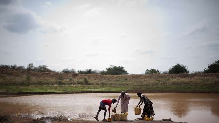 Menschen schoepfen Wasser aus einem See in Kanister, Kenia, 2011.