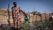 Eine Kleinbäuerin im Südsudan gießt ihre Pflanzen