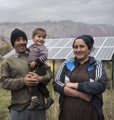 Eine Familie vor ihrer Solaranlage in Tadschikistan.